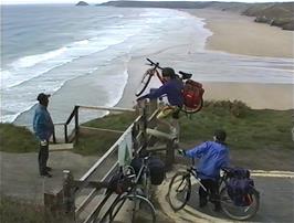 Neil helps carry the bikes over the style on the track to Perranporth YH